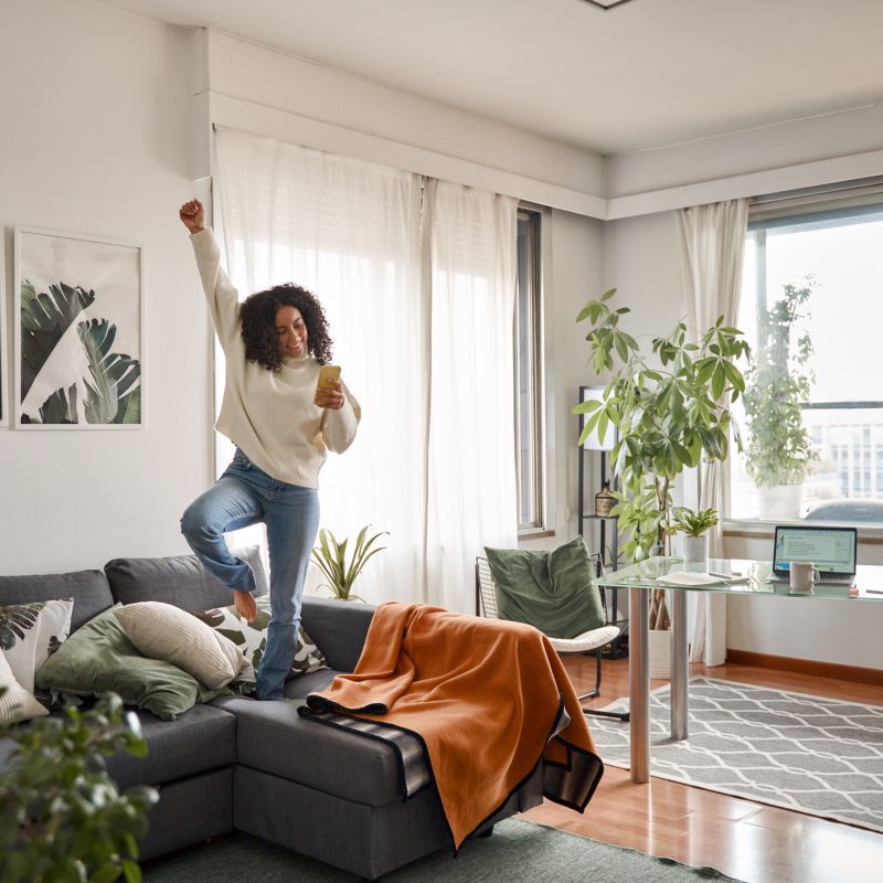 A woman dancing in her apartment decorated with damage-free decor.